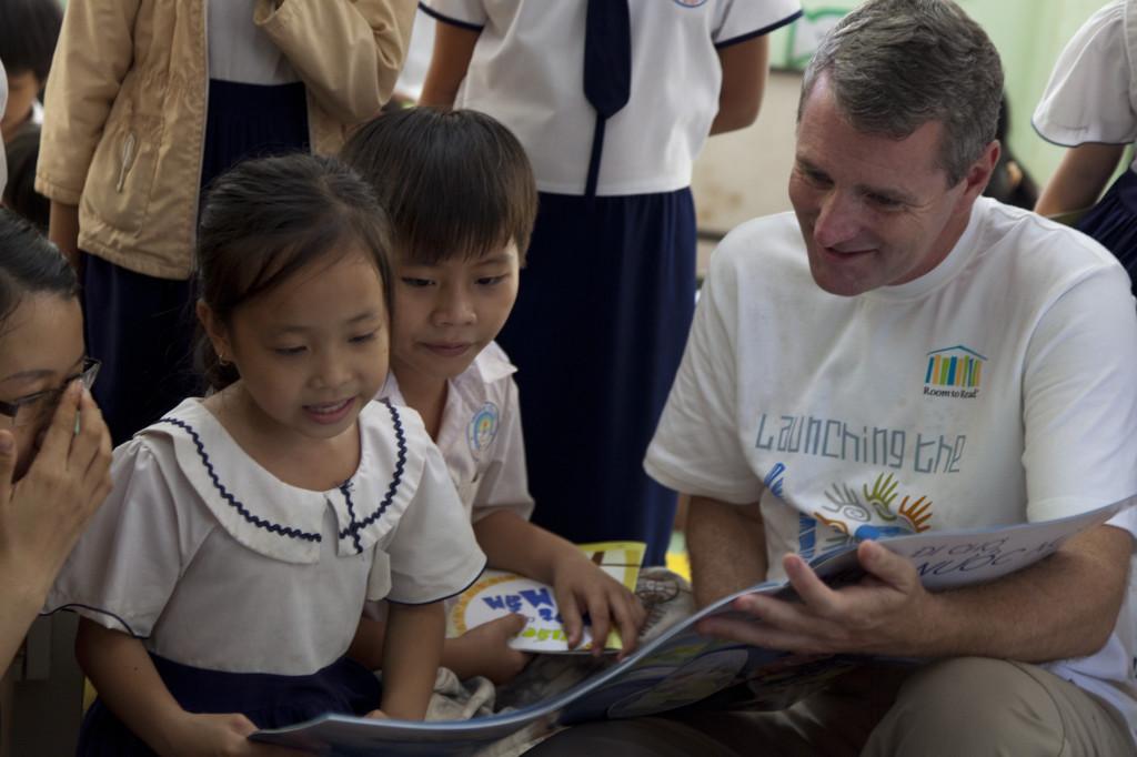 John Woods reading to some kids in Nepal with the books he brought over.