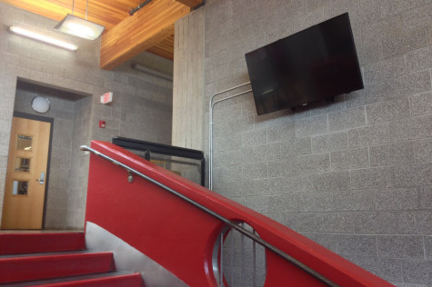 Students look forward to the new television hanging by the red staircase.