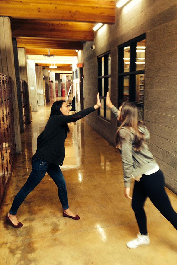 Freshman Madison Osberger-Low makes friends with senior Caroline DeRosa as they pass by each other in the AHS halls.