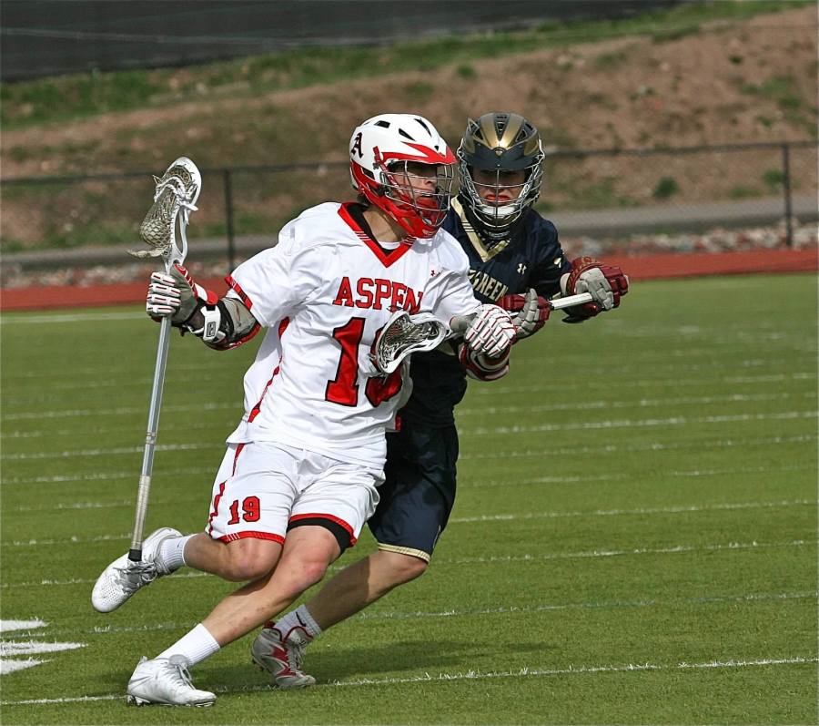 Senior John Heaphey (19) protects the ball from a defender. Heaphey and the lacrosse team will try to build off of a great season last year and help AHS achieve their goal of a state championship. 
