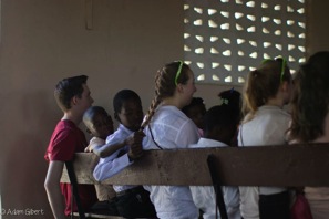 Haitian kids touch junior Anna Belinskis hair in awe of the color.