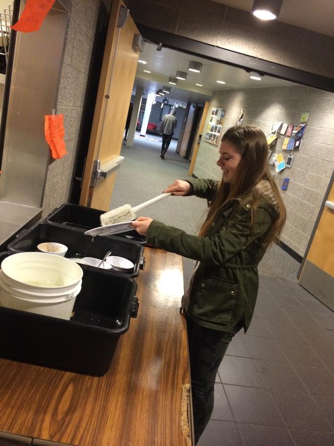 A freshmen uses her new skills to clean dishes after lunch on Friday.
