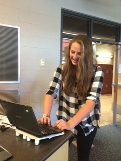 Junior Melody Lempke signs in at the library front desk. 