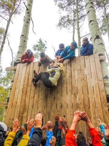 8th students work together last fall to overcome one of the obstacles at basecamp called The Wall