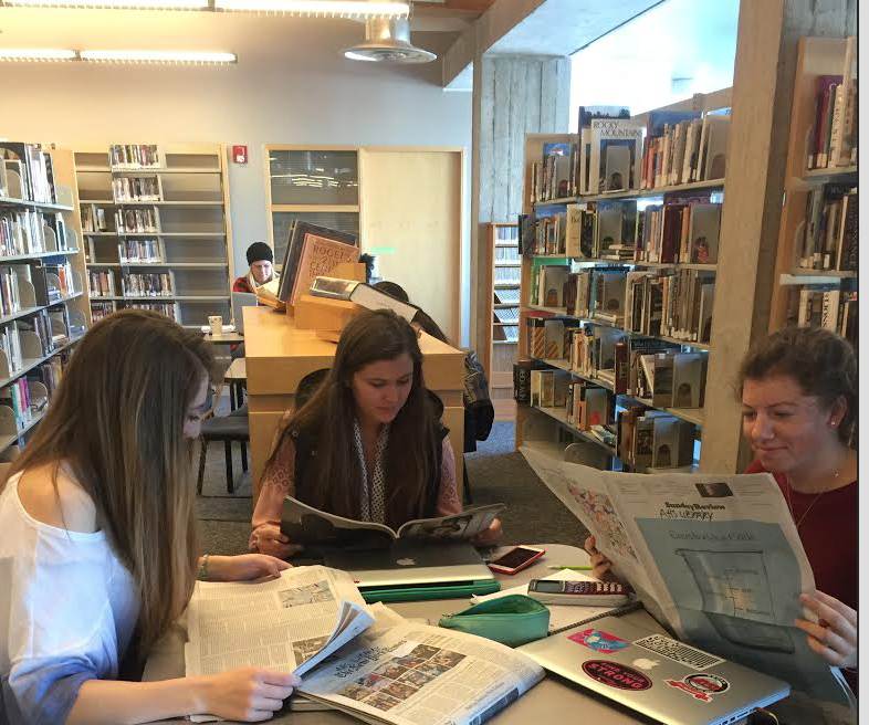 AHS juniors Anja Larson, Kaia Veresilovic, and Adair Patella read the news in the school library.