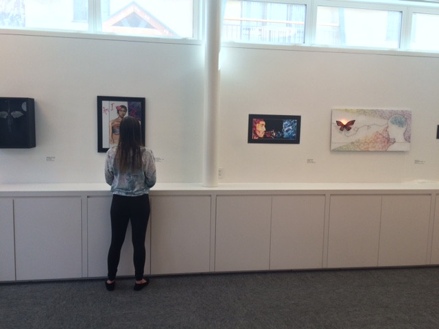 Junior Carson Friedland walks around the exhibit “Generation Now,” observing the piece “Am I Pretty Yet?”. To the right of her is “Untitled”. 
