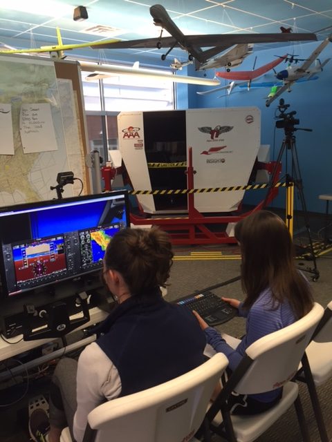 High school students Juliette Woodrow and Grace Ferguson fly the desktop simulator 