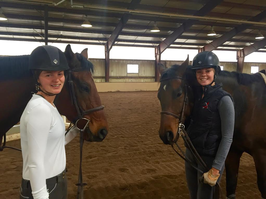 Eloise Clark (left) and Carter Cheo (right) pose with team horses on a Sunday morning, when practices are held.
