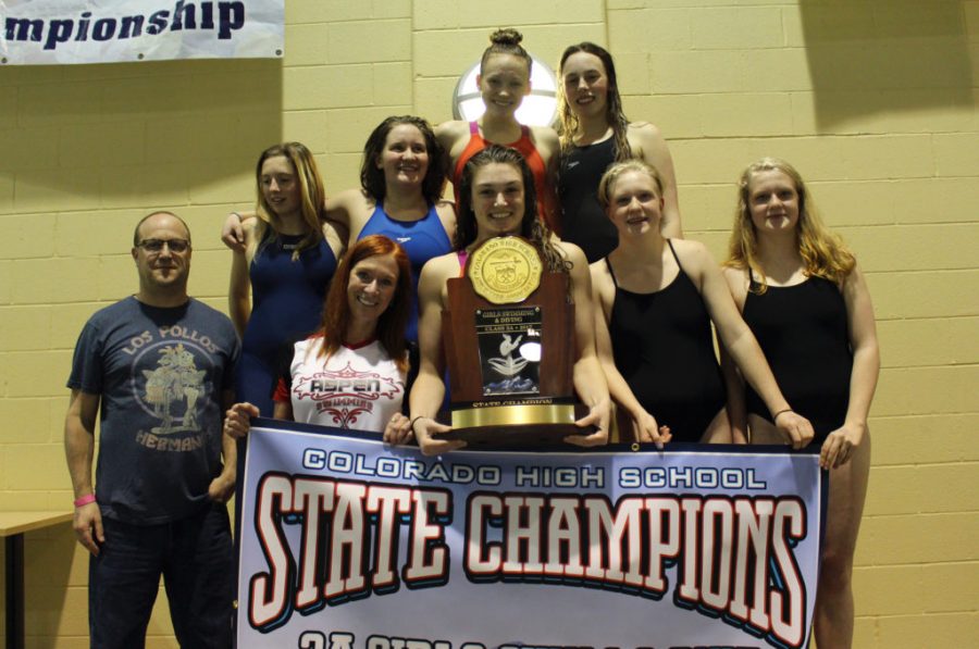 AHS girls swim team poses with banner and trophy 