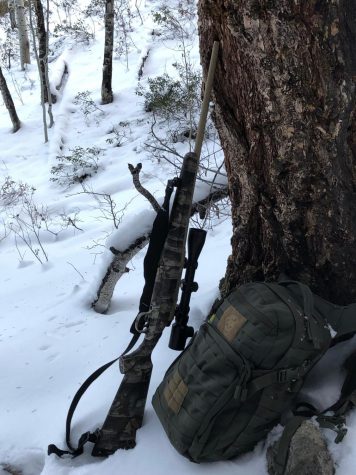 A picture of Ethan Linns hunting rifle leaning on a tree. 