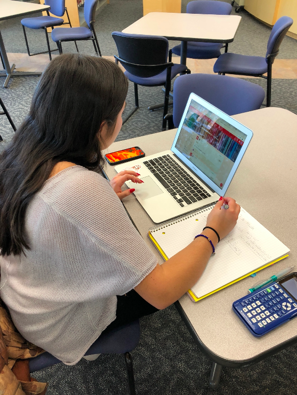 Pictured above is junior Jaelin Nakagawa completing some pre-exams busy work in the library. 