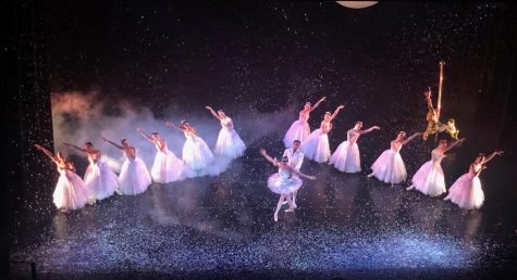 Fake snow falls to create a magical scene as dancers perform the Sugar Plum dance.