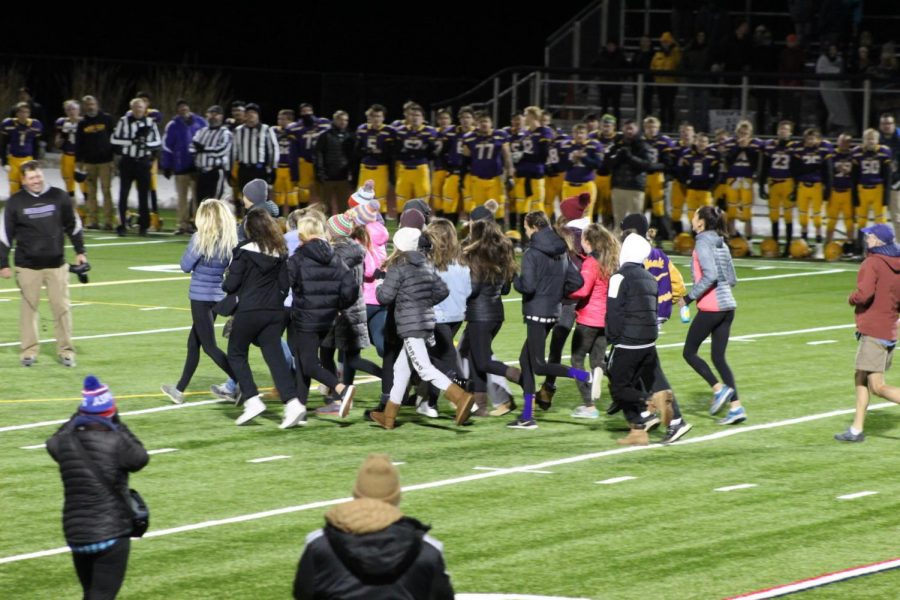 Members of AHS and BHS cross country teams deliver the game ball to Aspens last game of the season to raise money for Cayden Schaeffer.