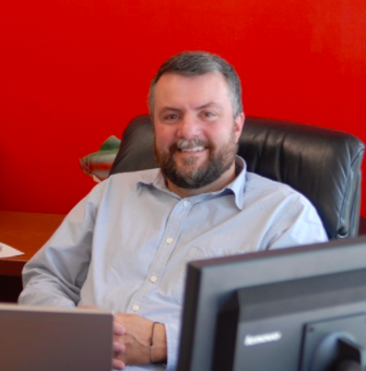 Current AHS Principal and future Assistant Superintendent Tharyn Mulberry poses at his desk.