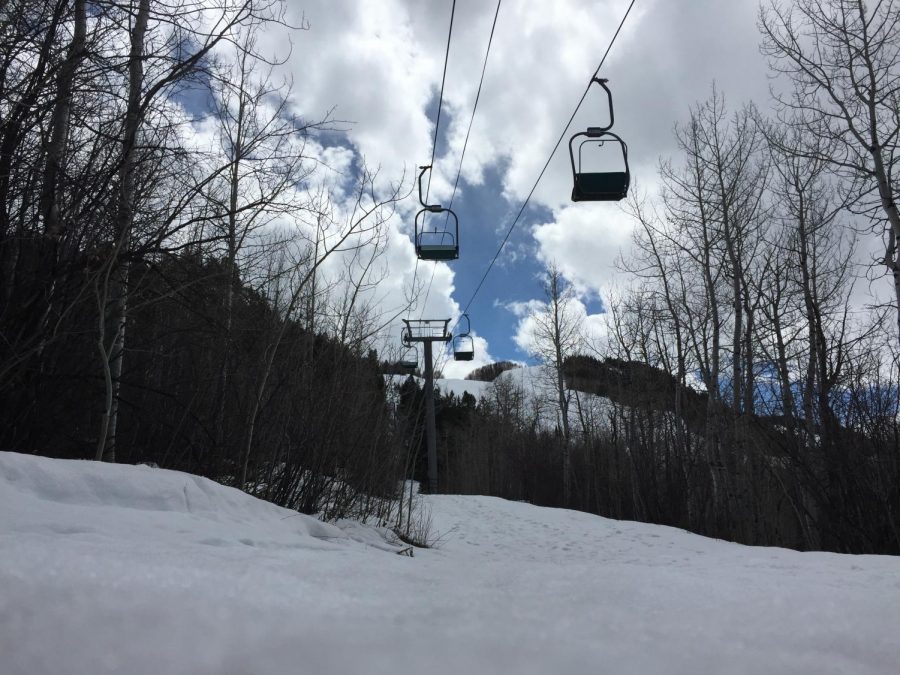 The+chairlifts+are+empty+but+sled+tracks+are+visible+in+the+mountains.