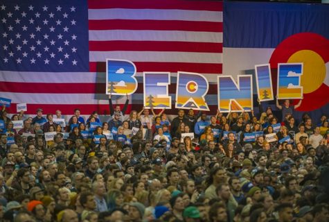 Participants at a rally for Bernie Sanders in Downtown Denver hold up a sign spelling his name.