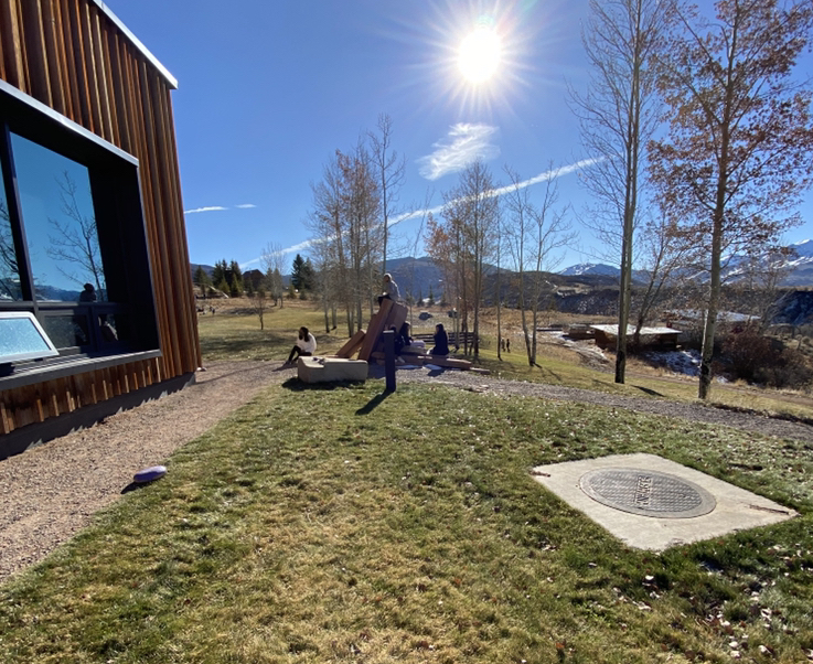 Students sit outside at Aspen Community School during in-person learning on a recent morning.