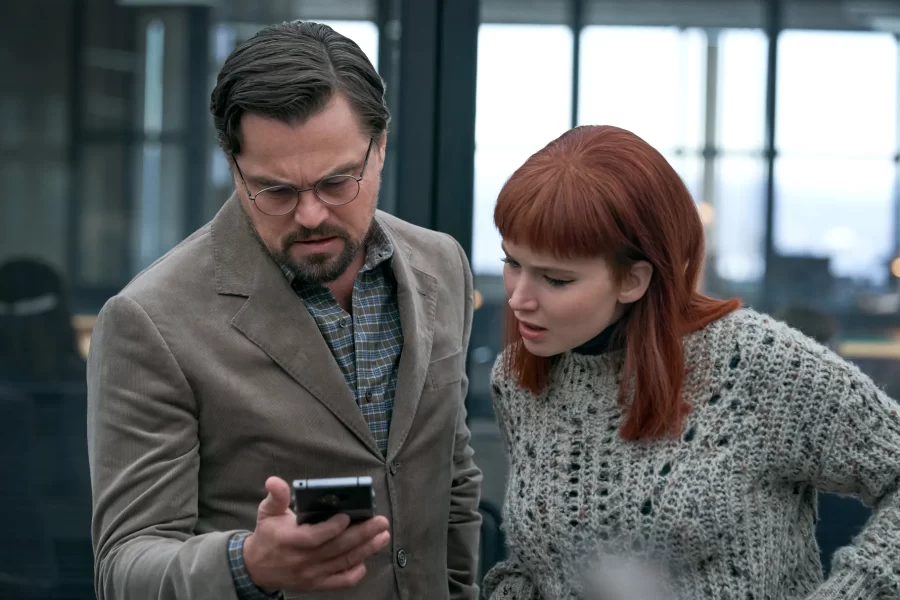 Dr. Randall Mindy (Leonardo DiCaprio) and Kate Dibiasky (Jennifer Lawrence) looking at Mindy’s phone after an interview in the film Dont Look Up