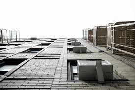 Air conditioners that use HFCs as coolants stacked in windows on a building.