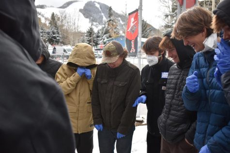 A group of junior and senior students gather around a first aid demonstration during Aspen Mountain Guide School training, led by Brent Maiolo.