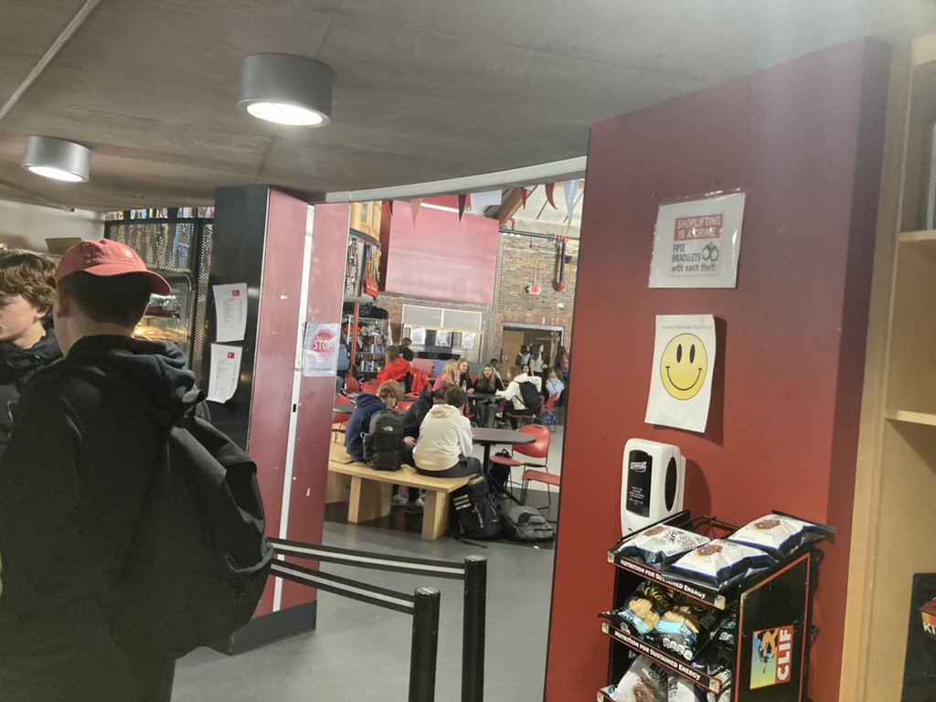 AHS students standing in line in front of anti-theft signs at the cafe during their lunch.