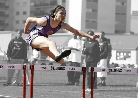 Women track athlete jumping over a hurdle at the Olympic Games.