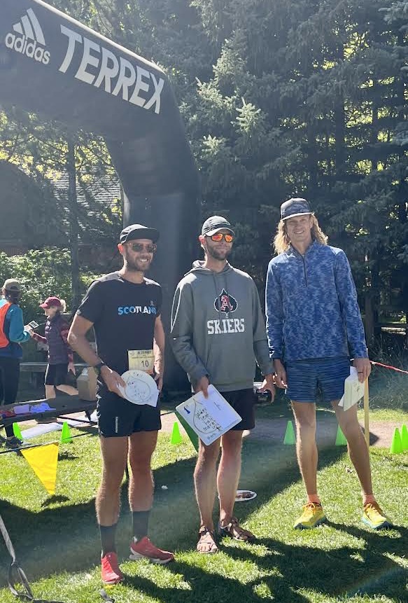 AHS teacher and head track & field coach Barton Tofany receiving his first-place award at the finish line of the Golden Leaf Half Marathon at Koch Park.