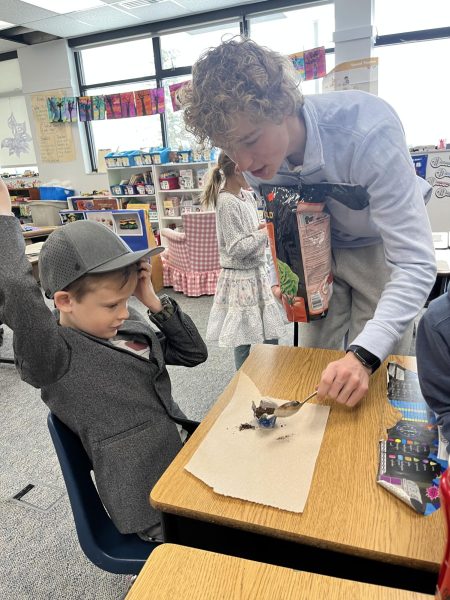 Ben Clark helps a second grade student during an Earth Day lesson. 