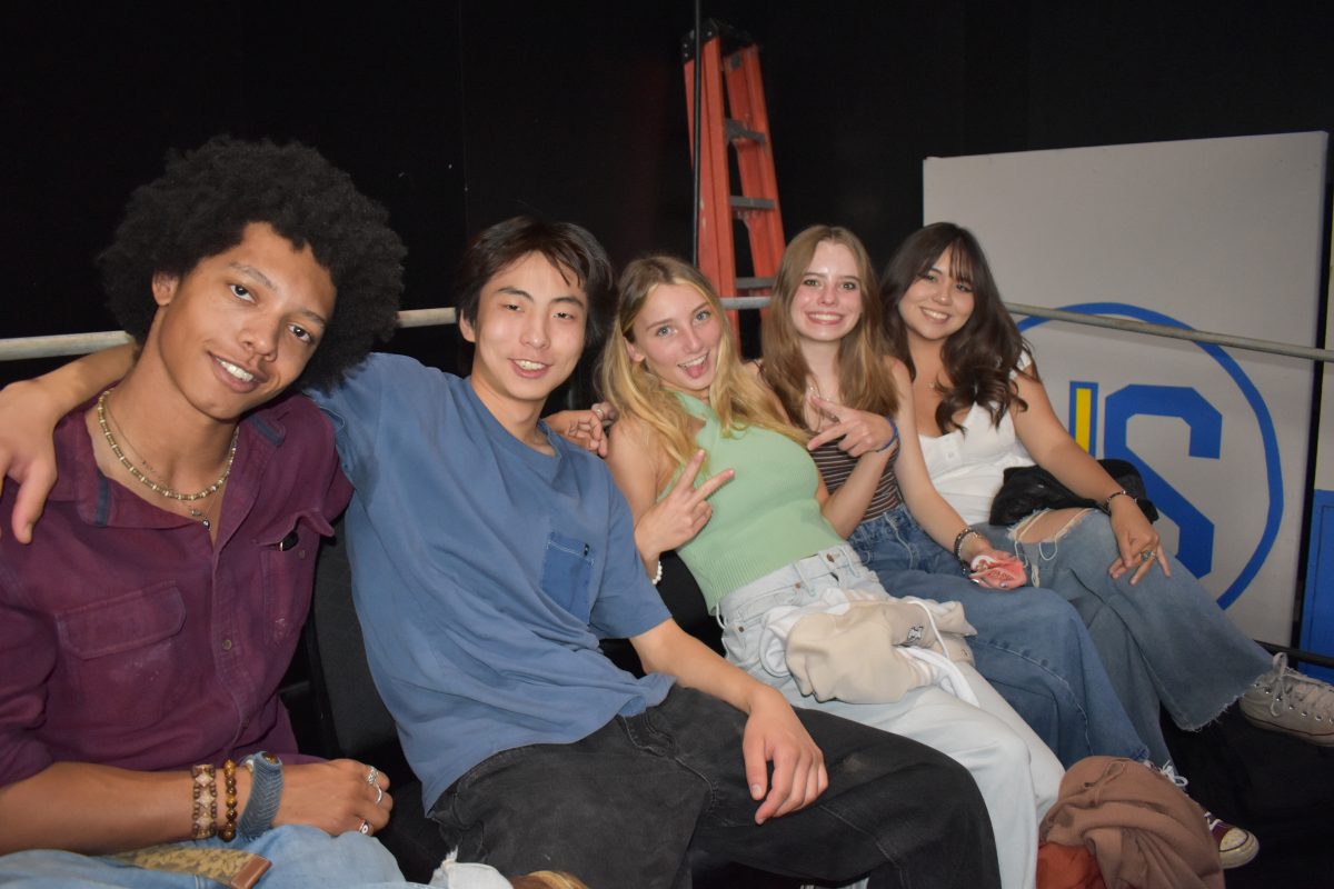 5 seniors enjoy eachother’s company in the Black Box Theater after the first class meeting of 2024.