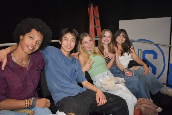 5 seniors enjoy eachother’s company in the Black Box Theater after the first class meeting of 2024.