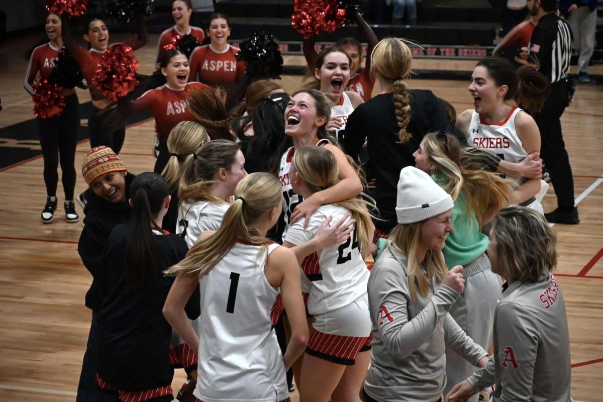 The Aspen girl's basketball team celebrating their first win of the 2025 season against Grand Valley.