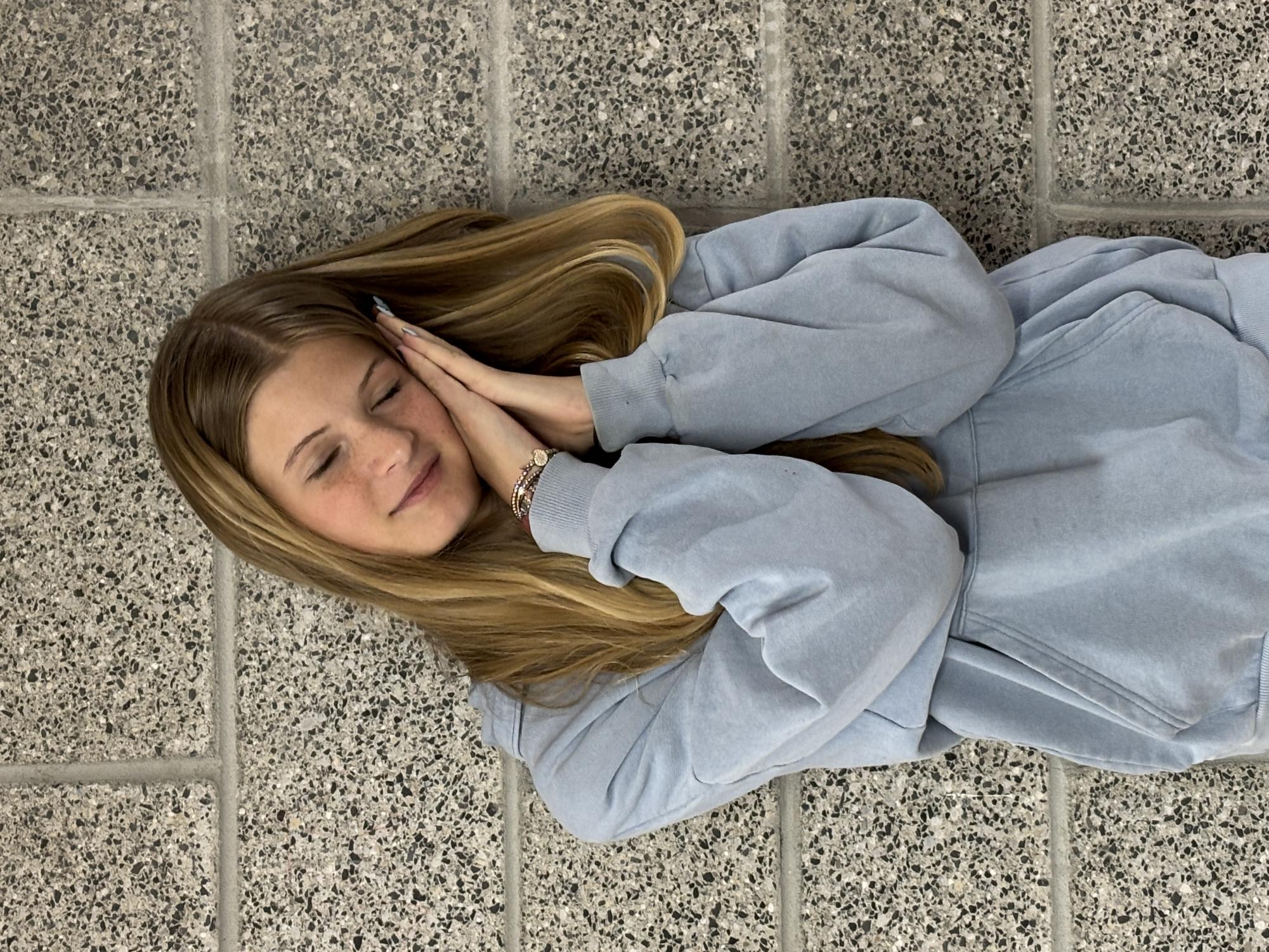 Sydney Klausmann poses like she is taking a nap at school. 