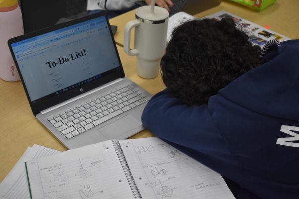 AHS Senior, Josie Jacobs poses as she falls asleep surrounded by a to-do list and homework, battling all the tasks of being a senior. 