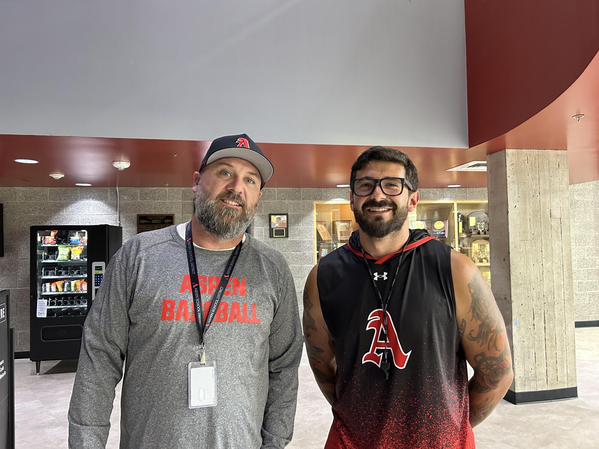 Brett Beville (left) and Bryce Sandoval (right) pose next to eachother in front of one of AHS's trophy cases.