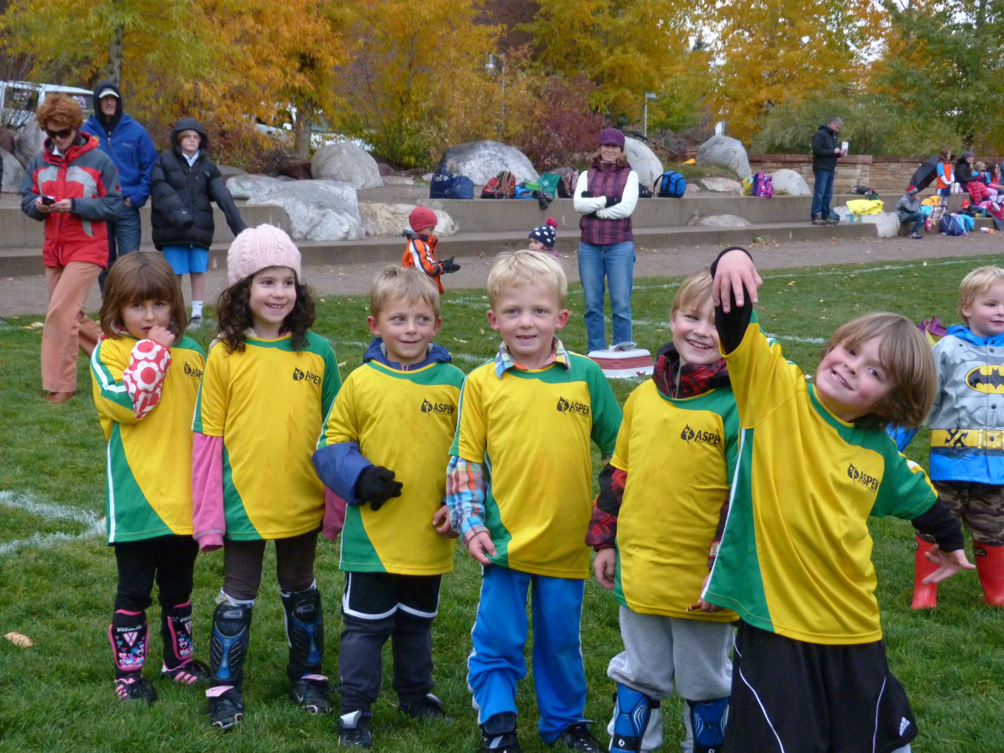 Youth soccer players stand in a line. 
