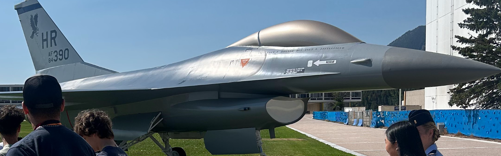 An F-16 prototype stands on display at the Air Force Academy as the Denver Aeronautics Ex Ed members walk past. Women have had the ability to fly these aircraft since 1993.