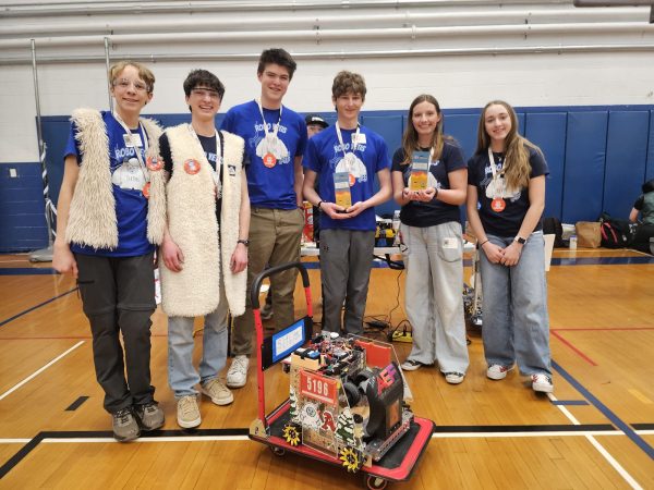 The AHS Robo Yetis pose with their robot at a competition.