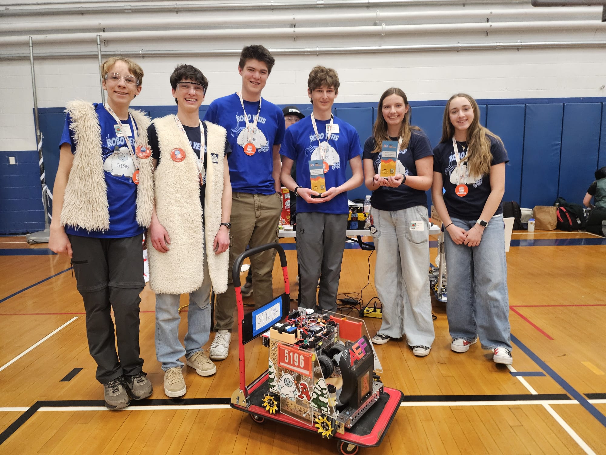 The AHS Robo Yetis pose with their robot at a competition.
